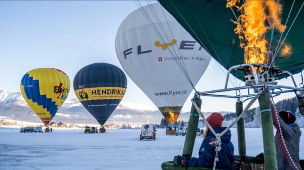 Heißluftballons beim Start während der Ballonwochen in Mauterndorf im verschneiten Salzburger Land