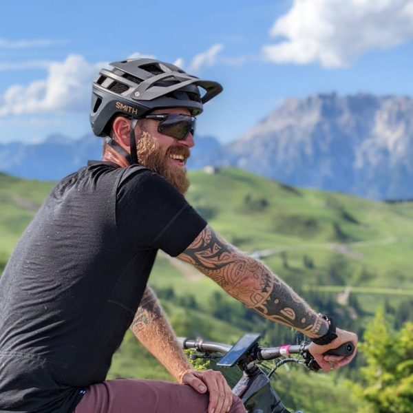 a man wearing a helmet and sunglasses sitting on a bicycle