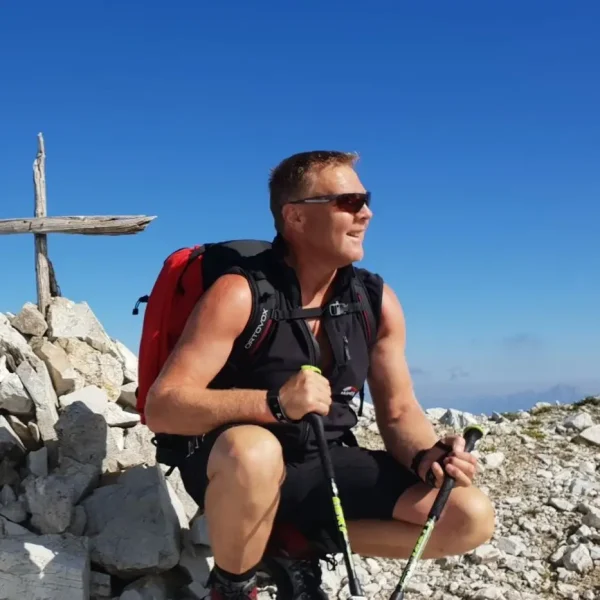 a man sitting on rocks with a cross on top of him