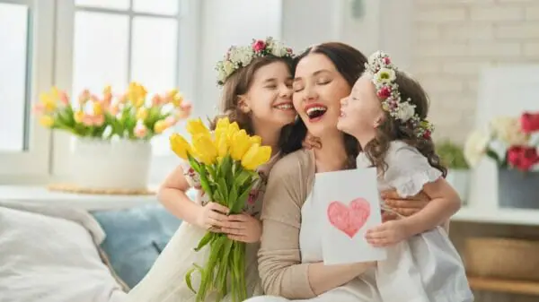 Mutter bekommt von ihren 2 Töchtern ein Geschenk und Blumen zum Muttertag