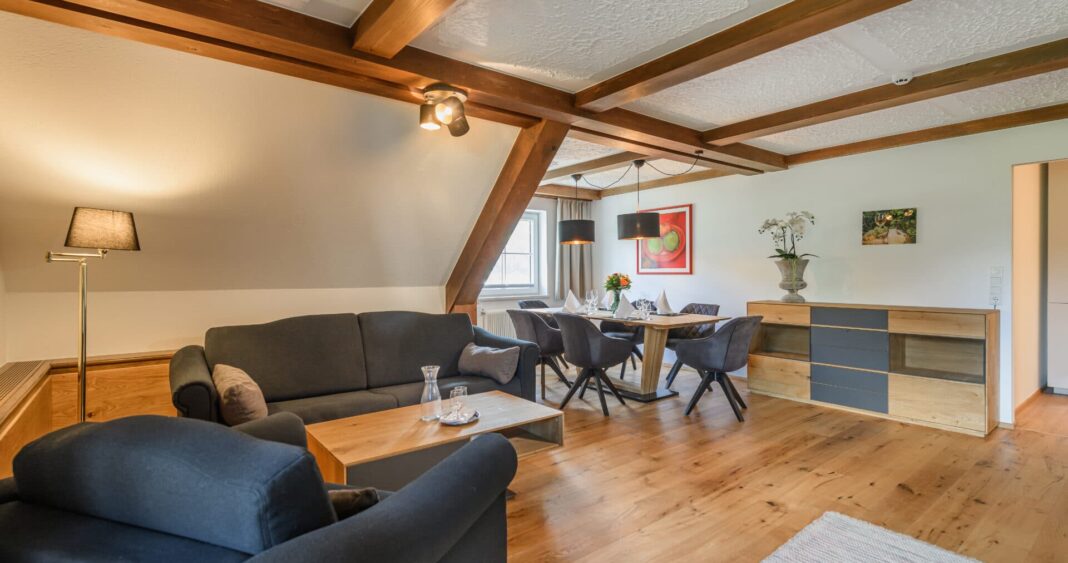 Wohnraum mit Sofaecke und Essbereich in der Suite des 4 Sterne Hotels Wastlwirt