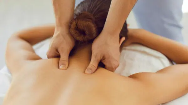 Frau erhält entspannende Nackenmassage im Wellnessbereich des Hotel Wastlwirt im Salzburger Lungau